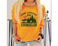 Customize this camp counselor shirt for personalized summer camp shirts, camping shirts for family, or to wear as matching group shirts for halloween! FREE SHIPPING All items are made to order and there are no returns on merchandise. Please be sure to double check your order before placement, and see sizing chart and size recommendations to find the best fit for you! Ideal for any situation, this UNISEX heavy blend crewneck sweatshirt is pure comfort. These garments are made from polyester and c Summer Camp Shirts, Camp Decor, Counselor Shirt, Camping Theme Party, Camp Shirts, Camping Shirts, Church Shirt, Camp Counselor, Group Shirts