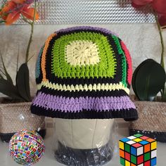 Step into a world of vintage charm with this one-of-a-kind granny square hat, meticulously handcrafted with love and care. This retro-inspired, crocheted bucket hat boasts a breathable design, perfect for adding a stylish flair to any outfit. Made from high-quality, soft yarn, this black hat features vibrant, multicolored flowers that bring a delightful pop of color and personality. Retro Multicolor Crochet Hat, Retro Crochet Hat, Retro Crochet Hat One Size, Retro Crochet Hats Made Of Yarn, Retro Crochet Hat One Size Fits Most, Retro Multicolor Crochet Cap Hat, Retro Multicolor Brimmed Crochet Hat, Retro Multicolor Crochet Cap, Handmade Multicolor Cloche Hat With Curved Brim