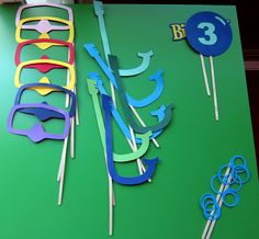 there are some cake toppers and scissors on the green table with blue circles around them