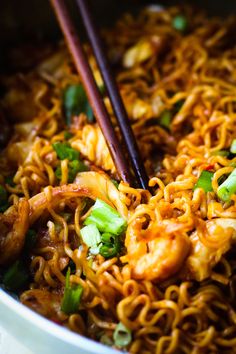 chopsticks sticking out of noodles in a bowl