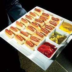 hot dogs and condiments on a white tray