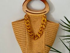 Crafted with quality materials, the raffia Ispie bag in turmeric tone adds a unique touch to your ensemble. Featuring wooden handles, this accessory brings charm to your stylish look. Yellow Bohemian Woven Bags, Yellow Square Bohemian Bag, Bohemian Yellow Crochet Shoulder Bag, Yellow Bohemian Handwoven Bag, Eco-friendly Yellow Straw Bag With Braided Handles, Raffia Bag, Top Handle Bags, Wooden Handles, Crochet Bag