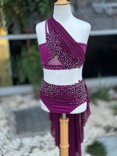 a mannequin is dressed in a purple and white dress with sequins