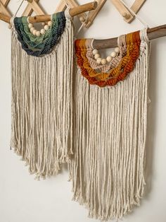 two wall hangings with beads and tassels attached to wooden clothes hangers