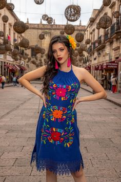 This Beautiful Halter Dress is the perfect dress for everyday use or a special event.  Its cute design and bold colors is the perfect combination, it also has elastic on the back for a tighter fit.  The large florals are all hand embroidered which means the embroidered details vary on each dress, making them one of a kind. Purchase the earrings modeled here: https://www.etsy.com/es/listing/918692155/aretes-mexicanos-de-corazon-con-flor-de?ref=listings_manager_grid Purchase the shoes modeled here Mexican Fiesta Dresses, Aztec Clothing, Mexican Sun, Mexican Clothing, Traditional Mexican Dress, Mexican Embroidered Dress, Fiesta Dress, Floral Ruffle Dress, Mexican Dress