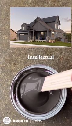 a person is holding a paint can with the word intelectual on it and an image of a house in the background