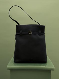 Manu Atelier – Tote du Jour Black Grained Modern Satchel With Palladium Hardware, Classic Square Bucket Bag For Travel, Modern Bucket Bag With Gold-tone Hardware For Travel, Modern Bucket Bag With Gold-tone Hardware For Everyday Use, Modern Travel Bucket Bag With Gold-tone Hardware, Modern Double Handle Bucket Bag For Business, Modern Leather Bucket Bag For Business, Modern Leather Business Bucket Bag, Modern Everyday Bucket Bag With Gold-tone Hardware