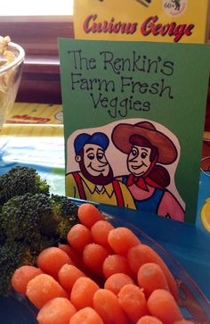 carrots and broccoli on a blue plate next to a book