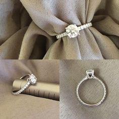 two diamond engagement rings sitting on top of a piece of cloth next to a pen