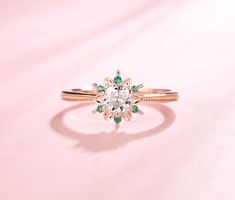 an engagement ring with a blue diamond in the center on a light pink background,