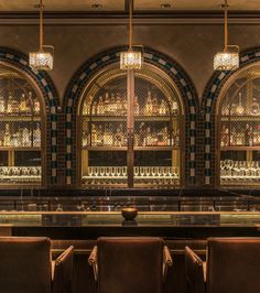 the bar is lined with brown leather chairs