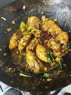 chicken and peppers cooking in a wok on the stove top with some seasoning