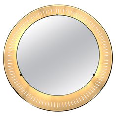 a round mirror with gold trim around the edges and an open circle at the bottom