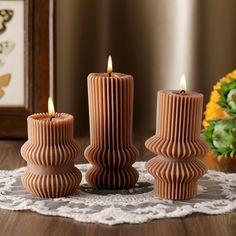 three candles sitting on top of a doily