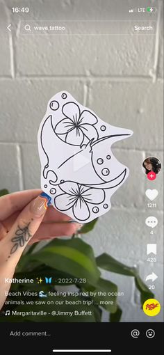 someone holding up a sticker with an image of a bird on it's face