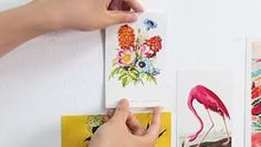 someone is holding up some cards with flamingos and flowers on them in front of a white wall