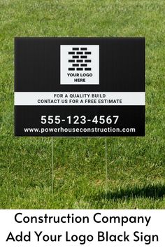 a black and white sign sitting in the grass