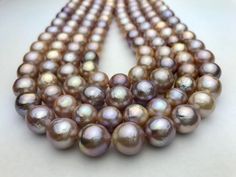 A strand of 10 to 11 mm beautiful round/near Edison pearls AA2 quality round pink and multicolor (pink, peach, cream). Fresh water Edison pearls. Natural colors. 37-40 pearls per strand. About $5 per pearl! We ship within 1-3 days of receiving your order from Hawaii by First Class Airmail. Shipping to the mainland USA usually takes 3 to 5 days. Shipping to anywhere in Hawaii usually takes 1 to 2 days. Shipping international usually takes about 1 week but can take up to several weeks depending on destination. All our pearl pictures were taken with our Samsung camera. We try and give you the best representation of what the pearls look like in person.  These pearls are grade A+ following the pearl grading scale from AAA, AA, A. None of these pearls have been treated in any way. We buy directl Pink High Luster Round Pearl Necklace, Pink High Luster Pearl Necklace, Pink Round Pearl Drop Necklace, Pink Pearl Drop Necklace, Pearl Pictures, Cream Fresh, 5 Dollar, Kona Coffee, Peach Cream