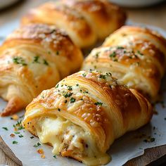 three croissants with cheese and herbs on top