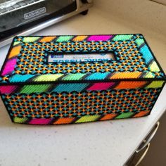 a multicolored box sitting on top of a counter next to a toaster