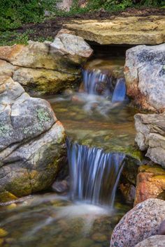 a small waterfall in the middle of some rocks