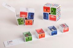 an assortment of colorful cubes on display with one missing the top and another missing the bottom