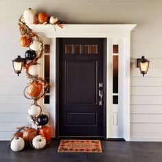 the front door is decorated with pumpkins and other decorations