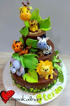 a three tiered cake decorated with jungle animals