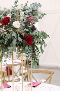 the centerpieces are adorned with red roses and greenery