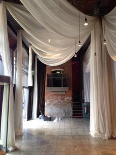 an open room with white drapes hanging from the ceiling