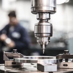 a machine that is working on some kind of metal object in a factory or workshop