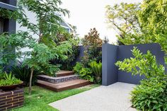 an outdoor garden with plants and steps leading to the house's front door is shown