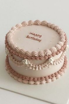 there is a three layer cake on top of a white plate with the words happy birthday written on it