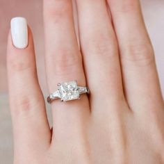 a woman's hand with a diamond ring on it