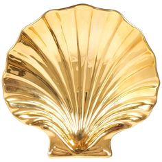 a golden shell shaped dish on a white background