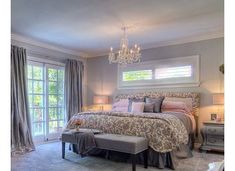 a bedroom with a chandelier hanging from the ceiling and a bed in it