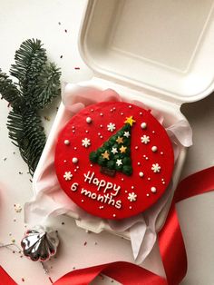 a decorated christmas cookie in a box with red ribbon