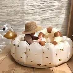 a little boy sitting on top of a white inflatable bed next to a stuffed animal