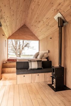 a room with wood floors and a window that has a view of the trees outside