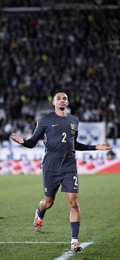 a soccer player is on the field with his arms out and eyes closed as he prepares to kick the ball