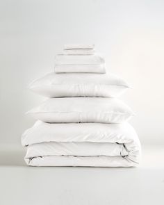 a stack of white pillows sitting on top of each other