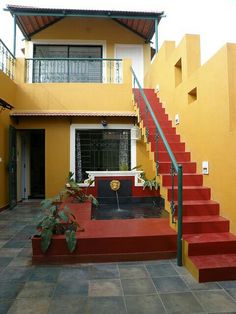 a yellow house with red steps leading up to it