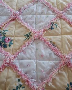 an old quilt with pink and green flowers on it