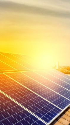 solar panels on the roof of a building at sunset or sunrise with city in background