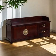 a wooden bench sitting on top of a hard wood floor next to a potted plant