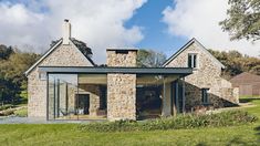 a stone house with glass walls and windows