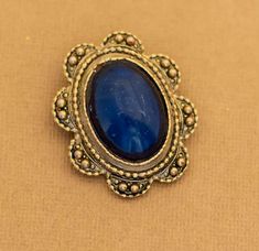 Vintage Royal Oval Art Deco Abyss Blue Brooch Notes:  Some scratching to the center  Features:  Brand: NA Color: Gold Tone, Blue Material: NA Size: Last image shows item with a ruler Blue Brooch, Ruler, Brooches, Gold Tones, Art Deco, Blue, Art