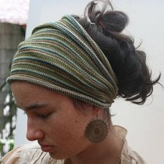 a woman with her eyes closed wearing a head wrap and earrings on top of her head