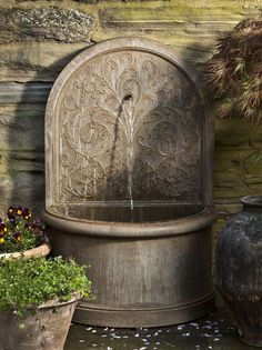 a water fountain surrounded by potted plants