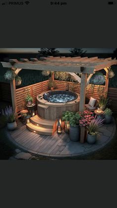 an outdoor hot tub surrounded by potted plants and lights in the night time, next to a pergolated deck